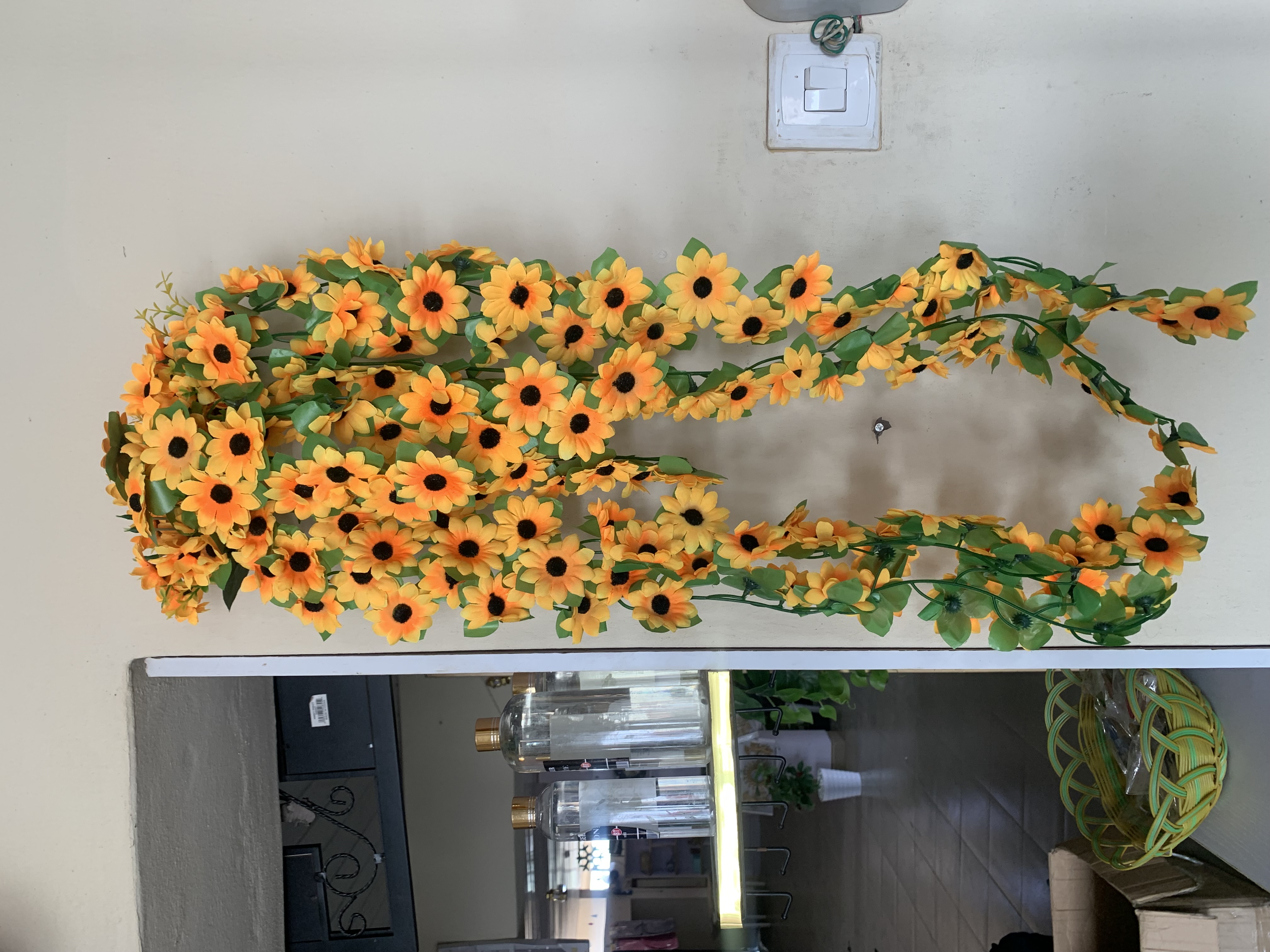 Dropping sunflowers in plastic wall vase second image